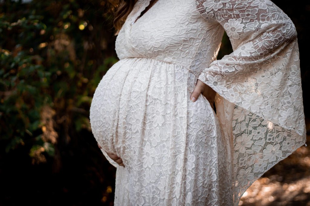 baby bump in ivory flowy dress in forest by horth hill for maternity photoshoot victoria bc photographer with alyssa orrego photography